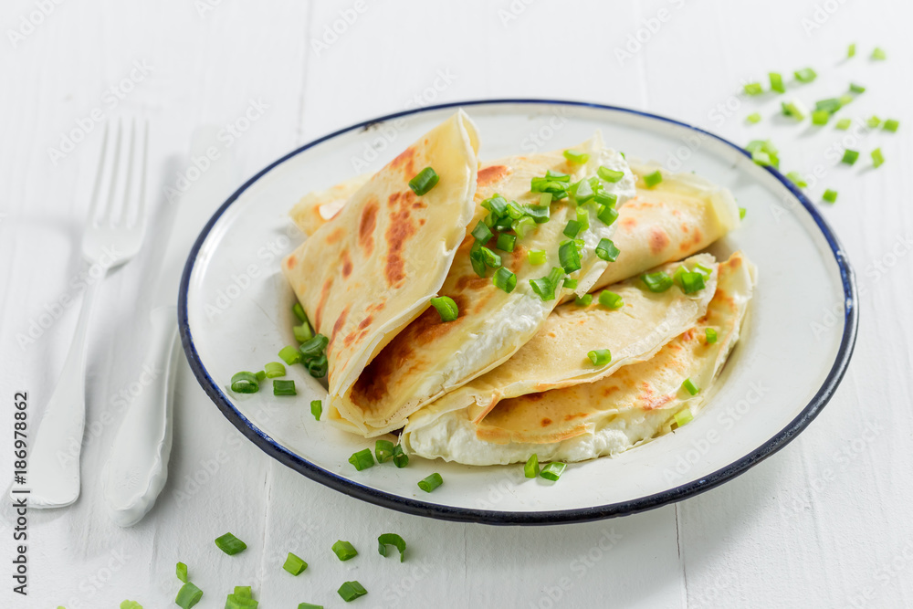 Tasty pancakes with cottage cheese and chive on white table