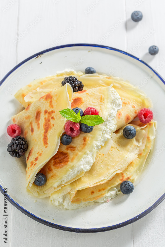 Delicious pancakes with berries, curd and powder sugar