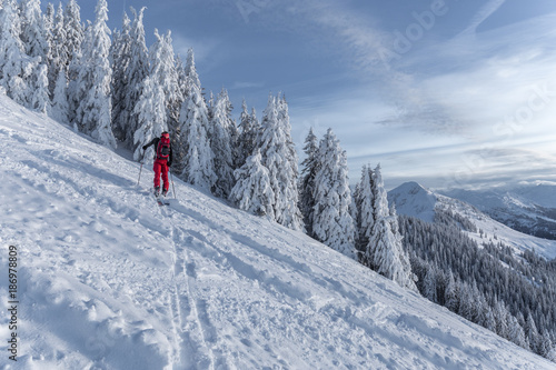 Mann beim Skitouren gehen im Gebirge bei verschneiter Landschaft © christophstoeckl