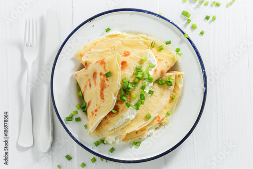 Pancakes with cottage cheese and chive on white table