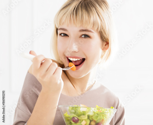 Young woman eating healthy salad.