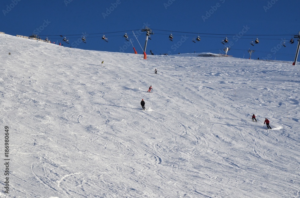 Skieurs descendant une piste des Pyrénées françaises Skieurs descendant une piste des Pyrénées françaises