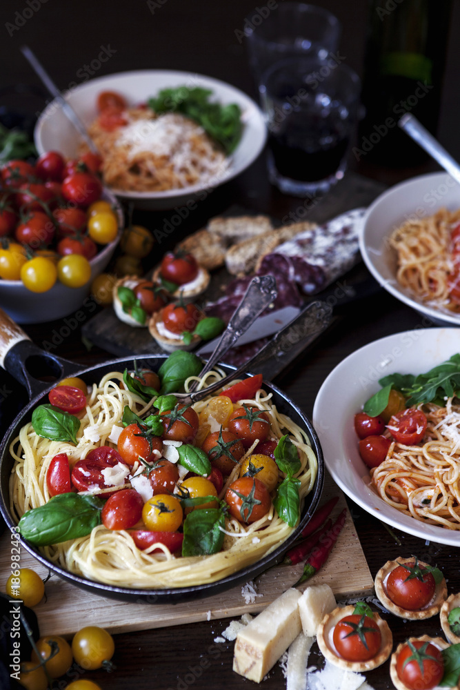Prepared spaghetti with tomatoes, basil leaves and parmesan