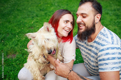 Portrait of happy young adult couple with dog