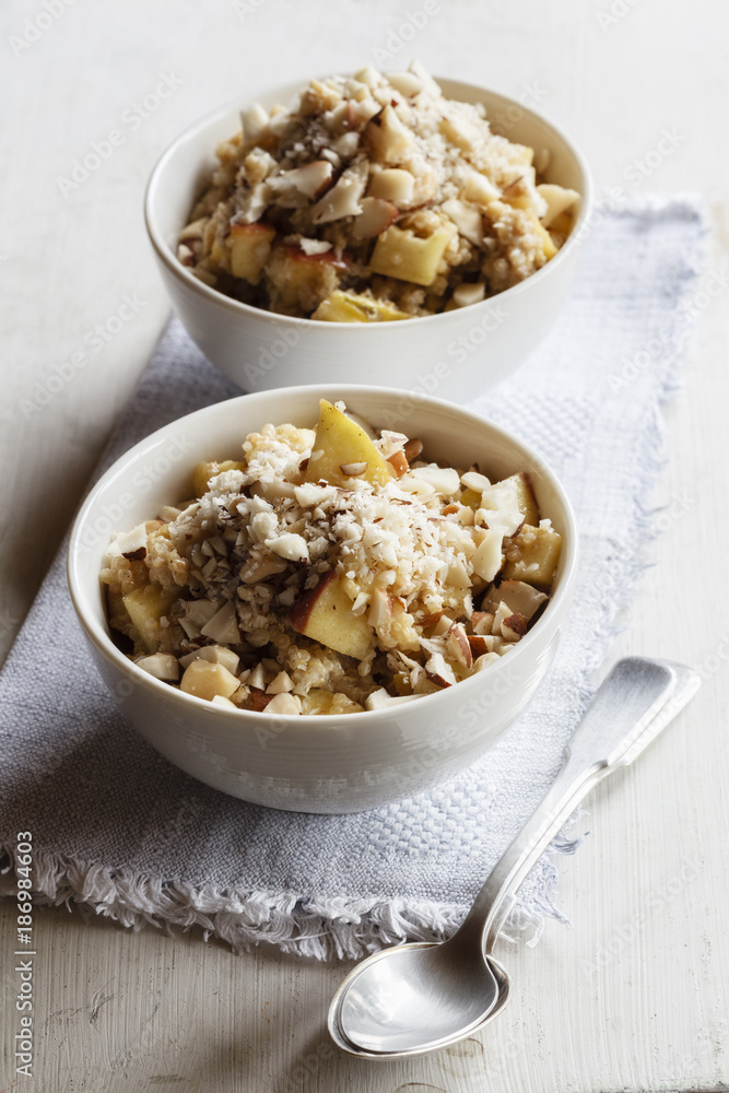 Two bowls of vegan quinoa porridge with apple and pecan Two bowls of vegan quinoa porridge with apple and pecan