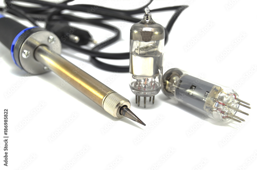 Radio components and electric soldering iron on white background close-up Radio components and electric soldering iron on white background close-up