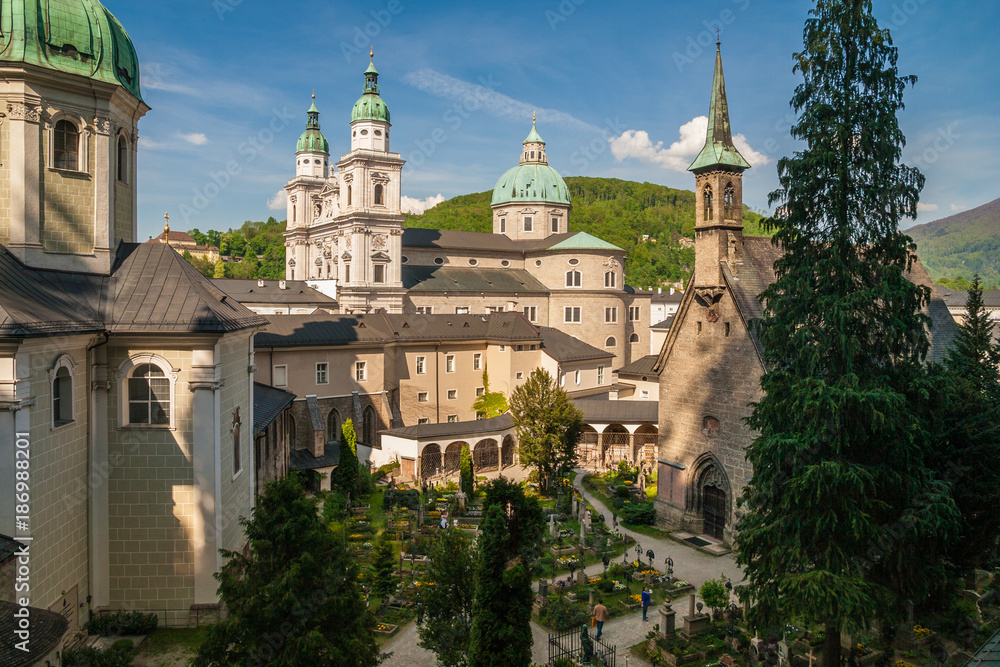 St. Peter's Cemetery in Salzburg, Austria which is one of the oldest and most beautiful cemeteries in the world. In the background you can see the Salzburg Cathedral.