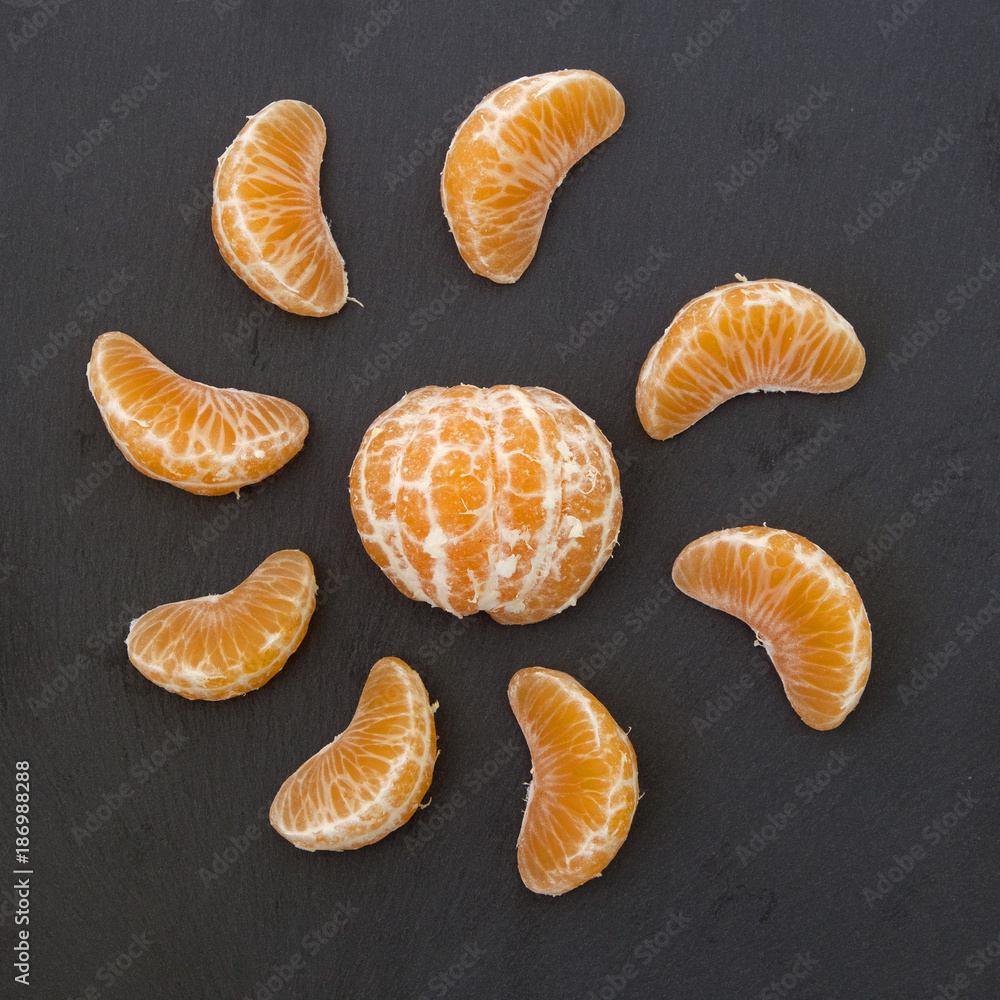 slices of mandarin on a black background. slices of mandarin on a black background.