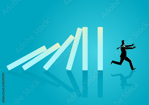 Businessman running away from domino effect
