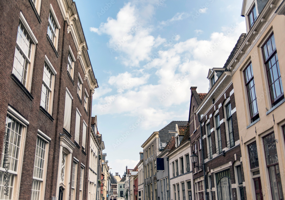 Street with old houses under blue cloudy sky. Deventer, Overijssel, Netherlands.