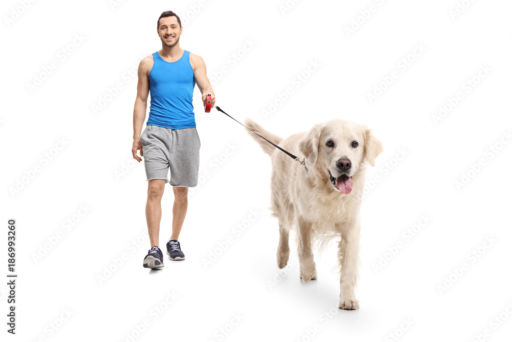 Young man in sportswear walking a dog