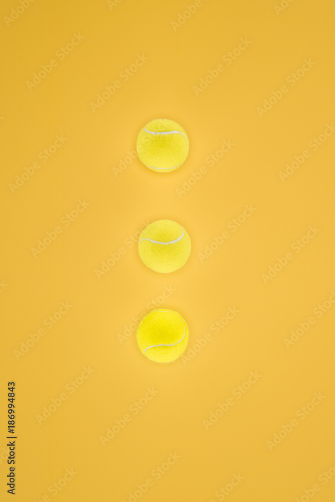 Tennis balls in a row isolated on orange background