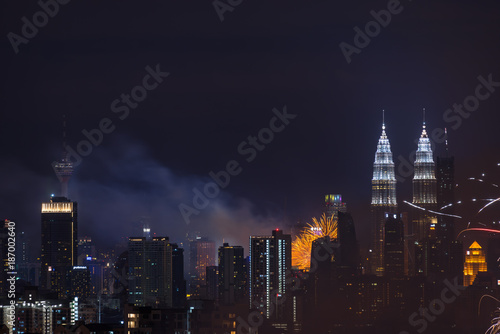 KUALA LUMPUR, MALAYSIA - 1ST JANUARY 2018; Fireworks explode near Malaysia's landmark Petronas Twin Towers during New Year celebrations in Kuala Lumpur.