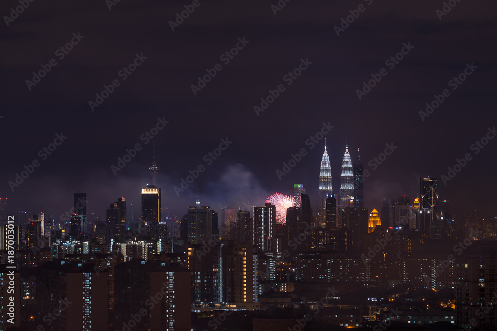 Obraz premium KUALA LUMPUR, MALAYSIA - 1ST JANUARY 2018; Fireworks explode near Malaysia's landmark Petronas Twin Towers during New Year celebrations in Kuala Lumpur.