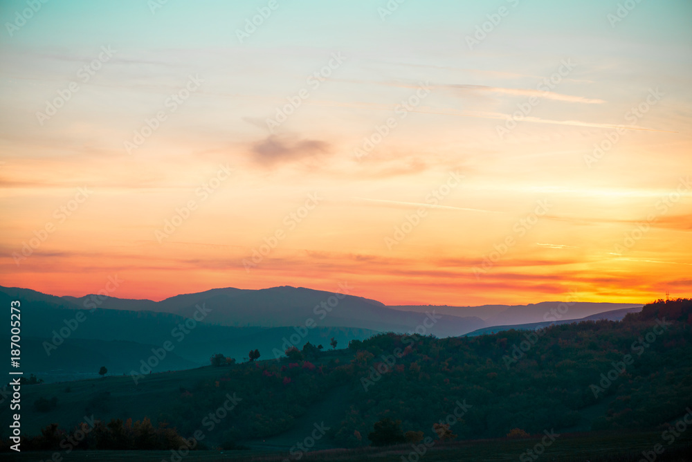 Romantic, bright and colorful sunset over a mountain range in Transilvania. Beautiful, colorful autumn background.