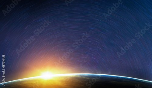 Landscape image of Earth, sunrise and star trail view from space. (Elements of this image furnished by NASA)