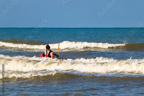 Man on a sea red kayak is paddling at the wave in Black sea