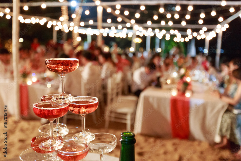 Pyramid from glasses of red wine on wedding party. Close-up of the pink champagne or wine pyramid in ceremony party.