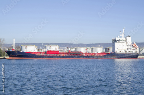 Big metal industrial oil tanks on port and tanker