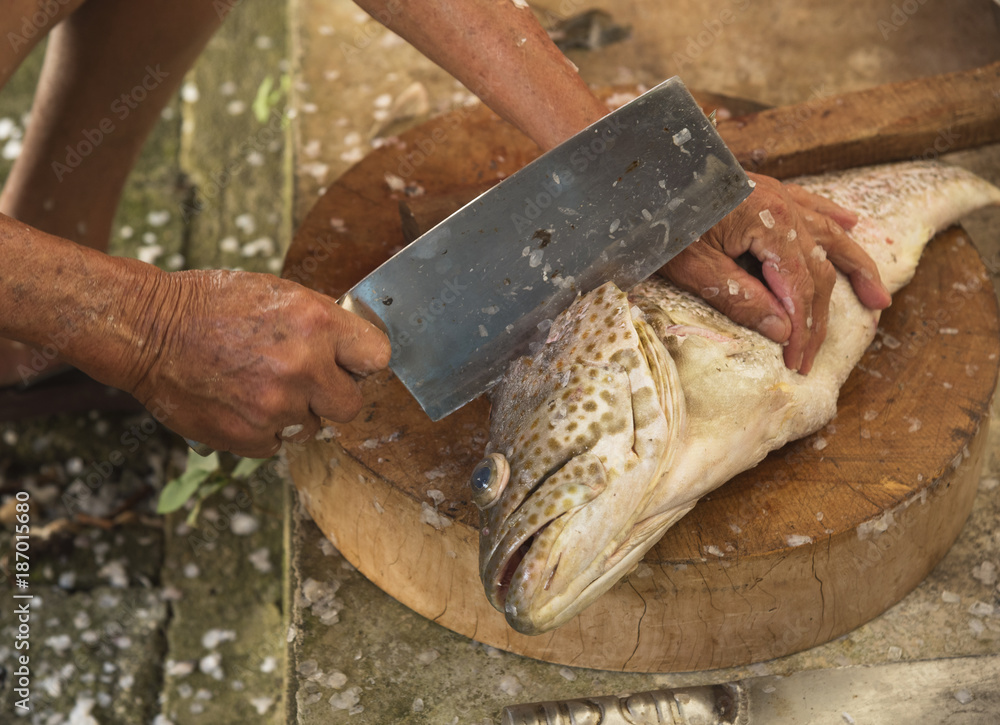 Preparing a grouper fish for food Preparing a grouper fish for food
