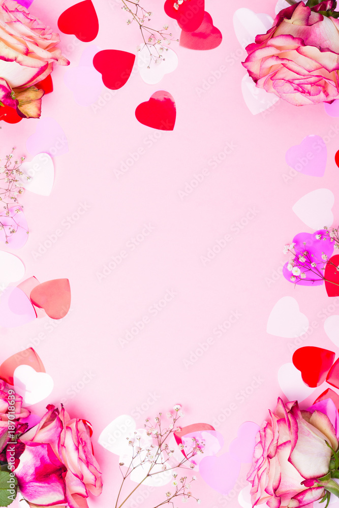 Beautiful pink rose, decorative confetti hearts and pink ribbon on pink Valentines day background