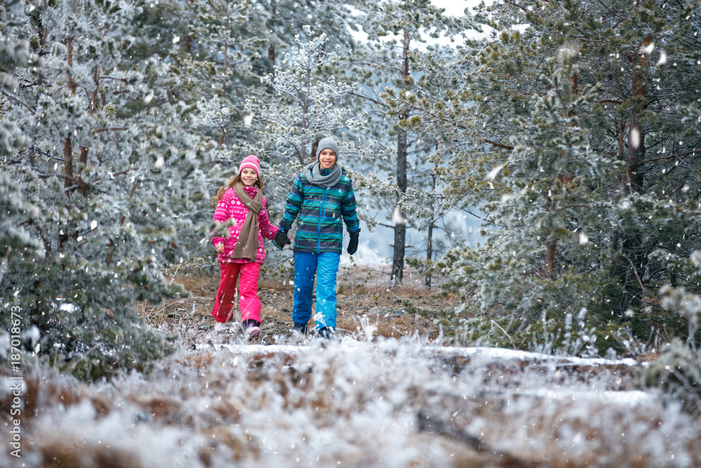Boy and girl walking in snowy mountain