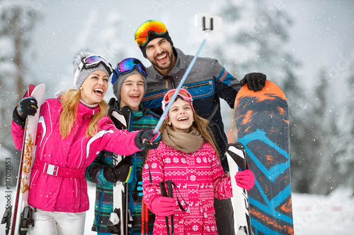 family taking selfie photo while skiing in snow