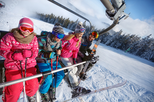 Parents with children in ski lift lifting on ski terrain