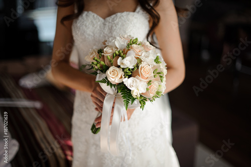 portrait of bride in white luxurious long wedding dress,veil and bouquet