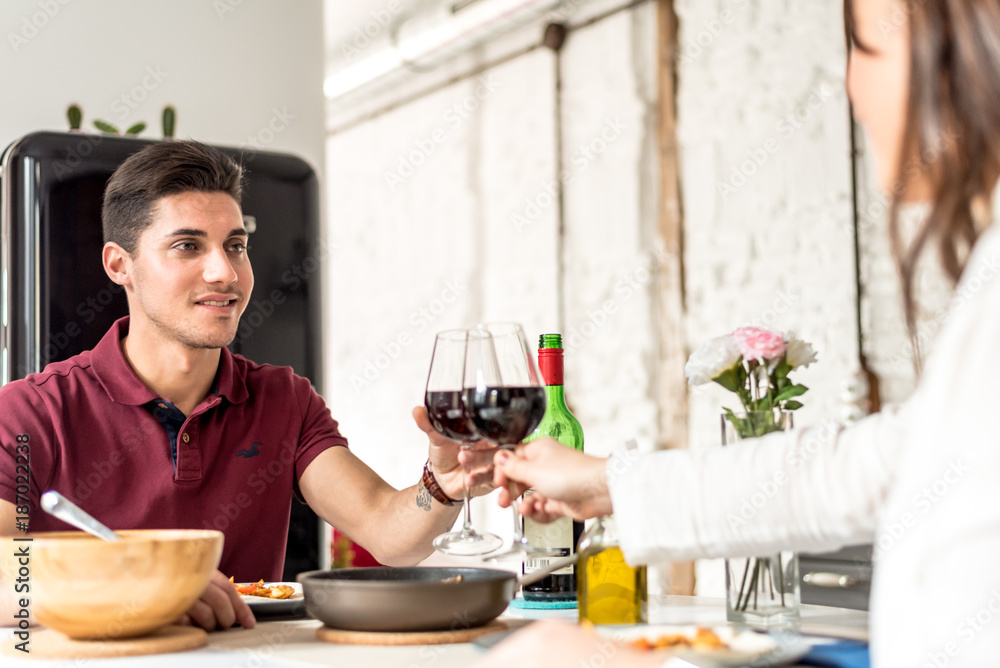 Happy young couple eating and drinking wine at home Happy young couple eating and drinking wine at home