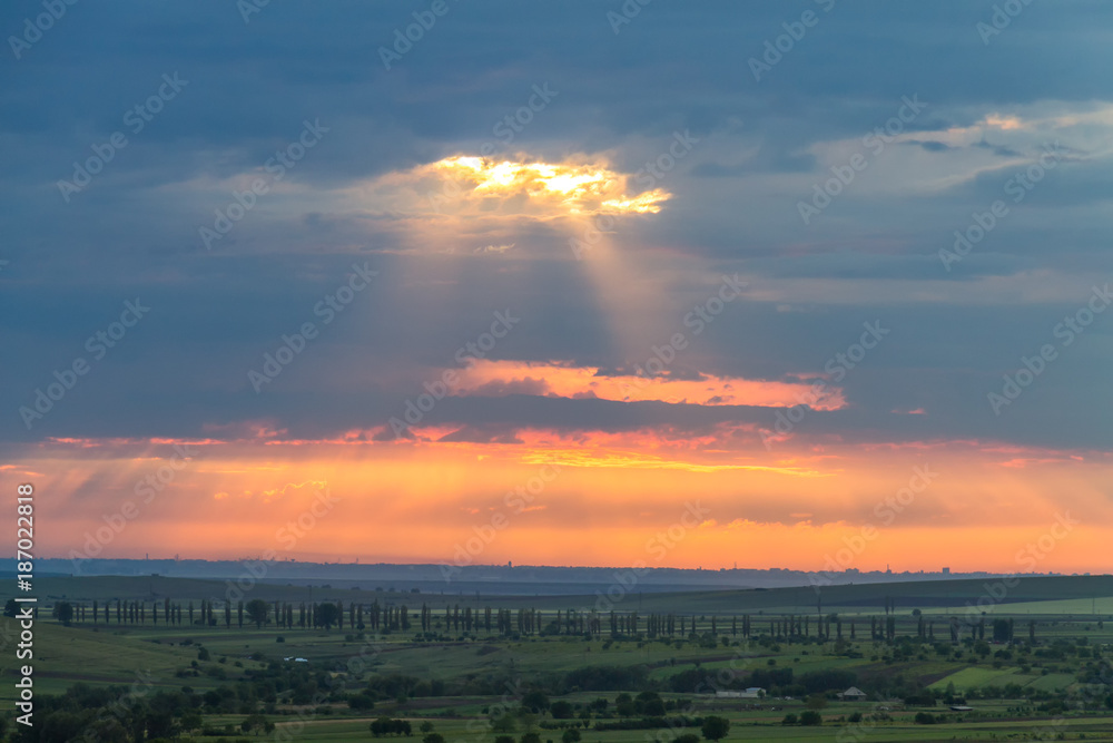 Cloudy colorful sunset over the hills and trees, Dobrogea, Romania Cloudy colorful sunset over the hills and trees, Dobrogea, Romania