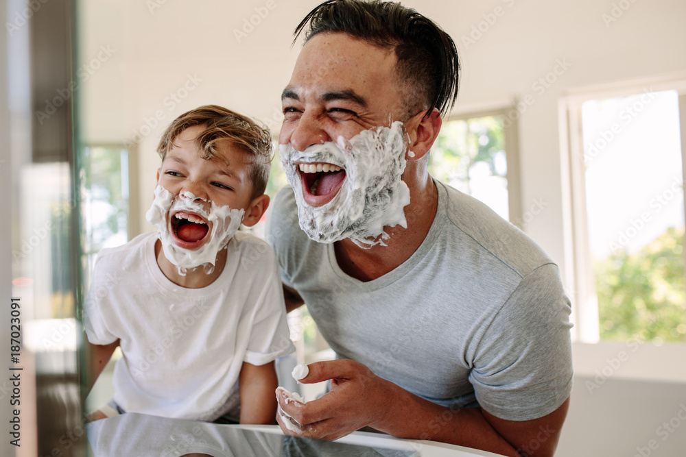 Father and son having fun while shaving in bathroom - obrazy, fototapety, plakaty 