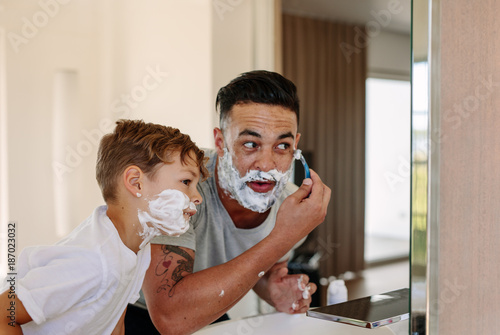 Fotografie Father and son shaving together in bathroom
