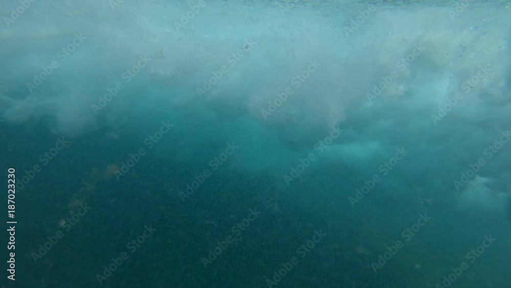 SLOW MOTION UNDERWATER: Small tube wave rushing towards rocky coast of Lobos. Miniature barrel wave breaking on sunny day on the beaches of Canary Islands. Bubbling ocean wave approaching sunlit coast SLOW MOTION UNDERWATER: Small tube wave rushing towards rocky coast of Lobos. Miniature barrel wave breaking on sunny day on the beaches of Canary Islands. Bubbling ocean wave approaching sunlit coast