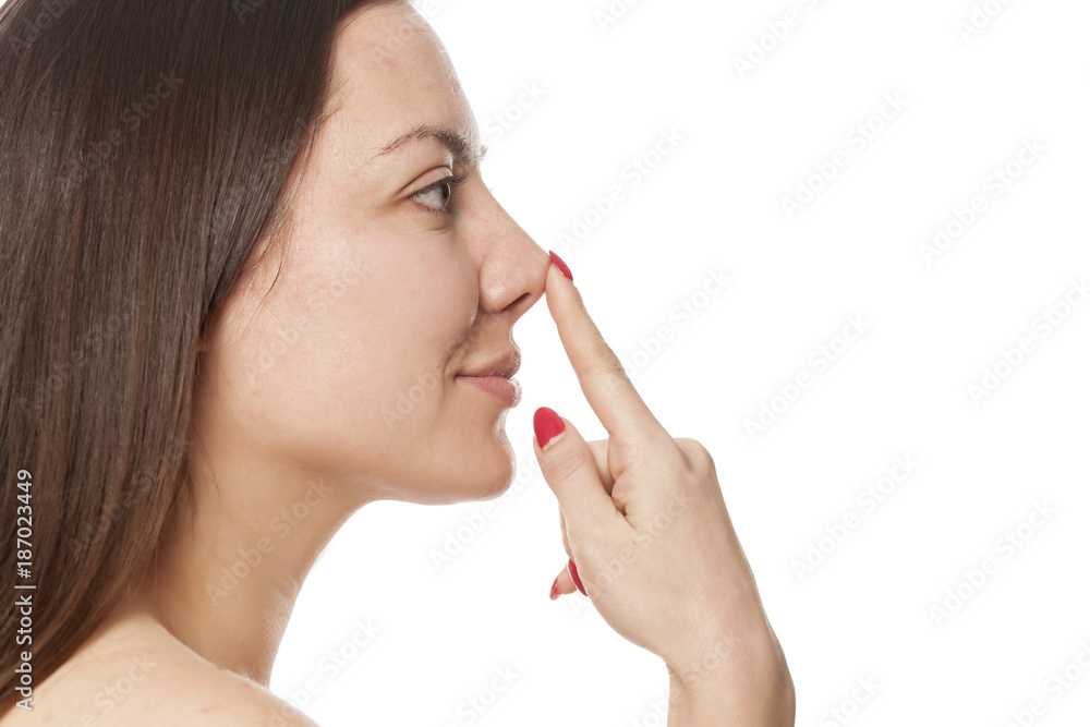woman touching jer nose on white background woman touching jer nose on white background