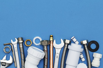 Plumbing tools and equipment overhead view on a blue background
