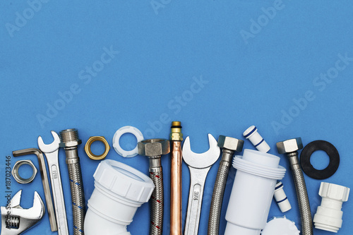 Slika na platnu Plumbing tools and equipment overhead view on a blue background