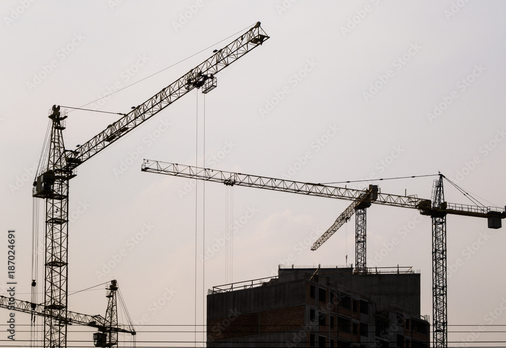 Construction site with cranes and building under construction Construction site with cranes and building under construction