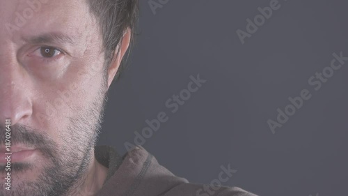 Half face portrait of pensive man, adult caucasian male looking at camera and thinking, ungraded flat style footage photo