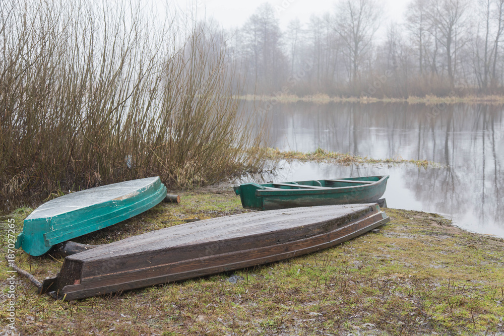 on the river bank against the background of water and trees moored boats on the river bank against the background of water and trees moored boats