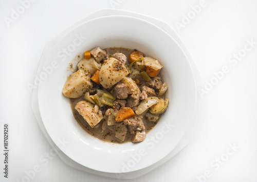 a bowl of beef stew with potatoes, carrots, celery, mushrooms and onions is shown