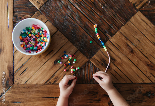 Preschool girl playing with beads. photo