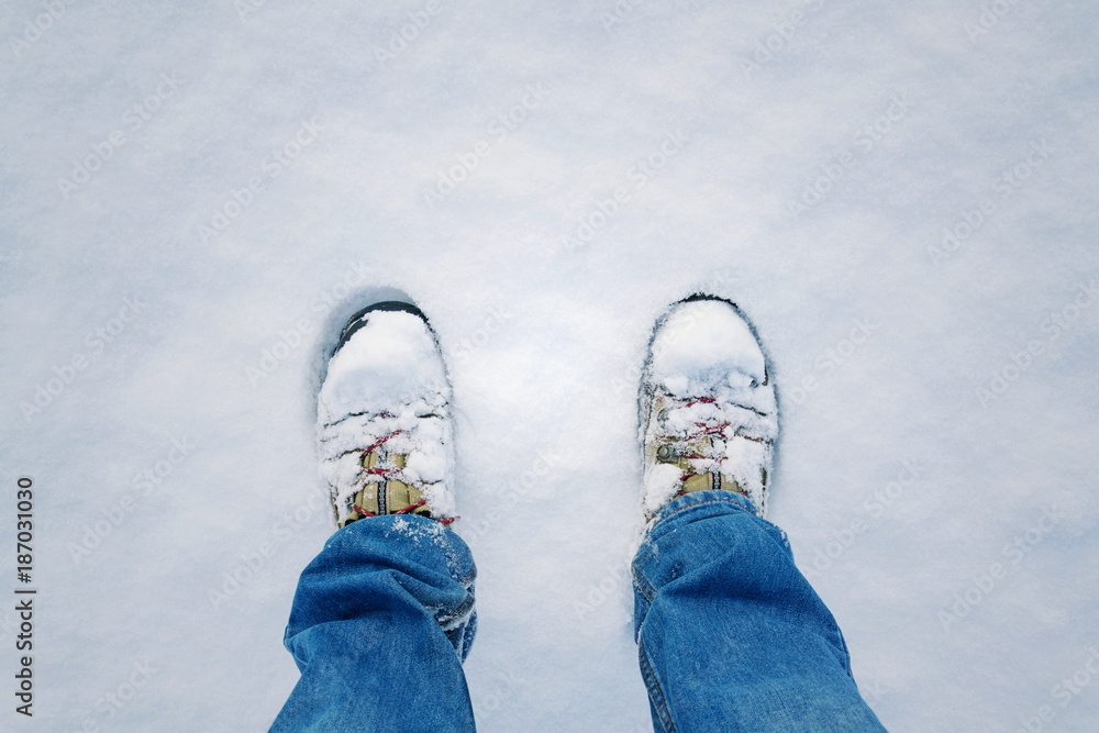 Top view of winter shoes footprint in fresh snow, blue jeans trousers, white copyspace background Top view of winter shoes footprint in fresh snow, blue jeans trousers, white copyspace background
