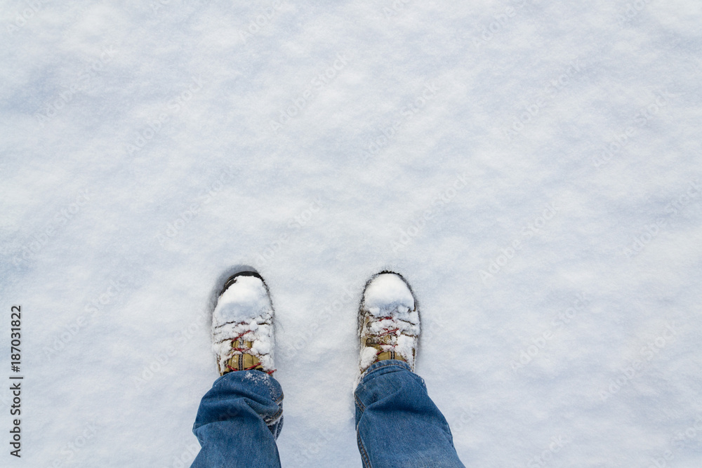 Top view of winter shoes footprint in fresh snow, blue jeans trousers, white copyspace background Top view of winter shoes footprint in fresh snow, blue jeans trousers, white copyspace background