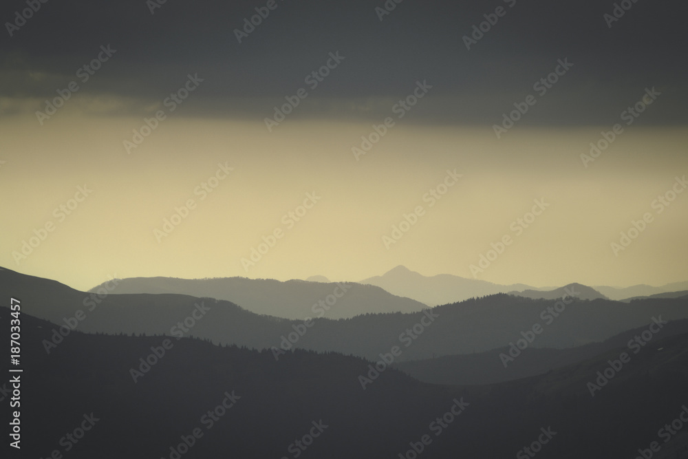 Abstract monochrome mountain landscape in retro photo tonality. Layers of mountain and haze in the hills. 