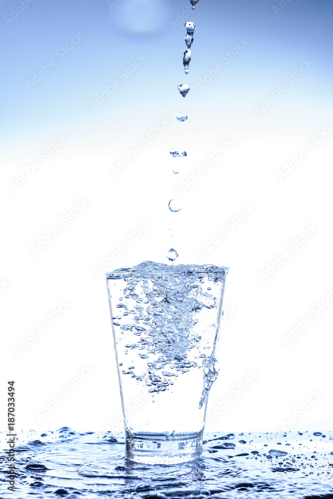 Pouring water and splashing in the glass with reflection on mirror. Pouring water and splashing in the glass with reflection on mirror.