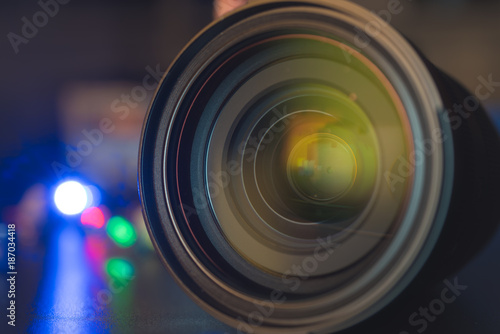 The photo or videocamera lens on dark background with lense reflections