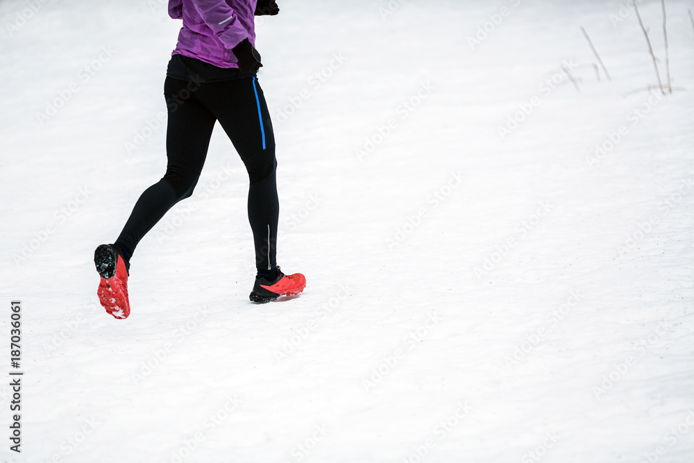 Trail running woman in winter mountains Trail running woman in winter mountains