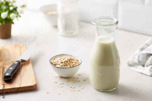 Jar of milk with oats in bowl. photo