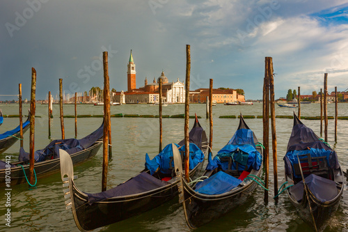 San Giorgio Maggiore church and Gondolas with dramatic sky after rain during sunset in Venice, Italy.